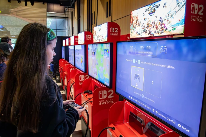 une jeune fille qui est entrain de jouer a mario kart world sur une borne
